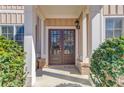 Elegant entryway showcasing double doors, trimmed with decorative pillars, and accented by lush greenery at 4155 Cami Way, Buford, GA 30519