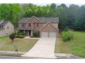 Charming two-story home with brick facade, two-car garage, and well-manicured lawn at 1440 Gallup Dr, Stockbridge, GA 30281