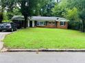 Inviting one-story brick home with lush green lawn and mature trees in a quiet neighborhood at 3727 Dial Dr, Stone Mountain, GA 30083
