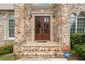 Elegant double front doors framed by brickwork and classic sconces at 4402 Income Cir, Ellenwood, GA 30294