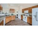 Well-lit kitchen with granite countertops, wood cabinets, modern appliances, and hardwood floors at 5997 Tate Dr, Austell, GA 30106