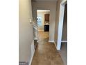 Hallway featuring neutral paint, tile flooring, and views to the kitchen, leading to other areas at 709 Kilkenny Cir, Lithonia, GA 30058