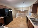 Kitchen boasts tile flooring, ample cabinetry, and modern appliances, seamlessly connecting to the living area at 709 Kilkenny Cir, Lithonia, GA 30058