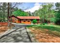 Quaint log cabin featuring a long asphalt driveway through a wooded lot at 1791 Walker Sw Rd, Conyers, GA 30094