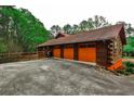 Three-car garage with log siding and ample concrete parking space at 1791 Walker Sw Rd, Conyers, GA 30094
