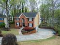 Two-story brick home boasts a spacious driveway and manicured front lawn at 1810 Talbot Ct, Lawrenceville, GA 30044