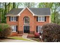 Brick facade home featuring large front window and black shutters surrounded by lush landscaping at 1810 Talbot Ct, Lawrenceville, GA 30044