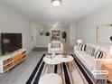 Bright living room with plush rug, white furniture, and modern decor at 7302 Par Four Way, Lithonia, GA 30038