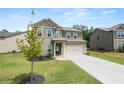 Inviting two-story home with a well-maintained lawn and a paved driveway, surrounded by lush greenery at 485 Auburn Crossing Dr, Auburn, GA 30011
