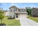Attractive two-story home with a neat front lawn and a driveway leading to an attached two-car garage at 485 Auburn Crossing Dr, Auburn, GA 30011