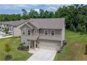 Well-maintained two-story home featuring a paved driveway, a two-car garage, and a green lawn at 485 Auburn Crossing Dr, Auburn, GA 30011