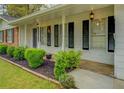Welcoming front porch featuring manicured landscaping, black shutters, and decorative lighting at 1283 Maple St, Conyers, GA 30013