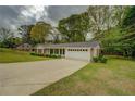 Charming one-story brick home with manicured lawn, black shutters, and a paved driveway at 1283 Maple St, Conyers, GA 30013
