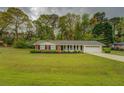 Charming one-story brick home with manicured lawn and tasteful landscaping and black shutters at 1283 Maple St, Conyers, GA 30013