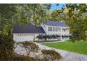 Charming two-story home with blue shutters, attached garage, and long driveway leading to a well-manicured lawn at 6493 Crooked Creek Pl, Lithonia, GA 30058