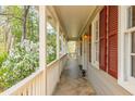 Inviting covered front porch with classic railings, shuttered windows, and exterior lighting at 6795 Brandon Mill Rd, Atlanta, GA 30328