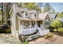 Two car garage and charming front porch featuring a stone and siding exterior at 9176 Lakeview Parkway, Villa Rica, GA 30180