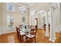 Elegant dining room with hardwood floors, columns, and modern light fixture at 535 Telford Pl, Atlanta, GA 30342
