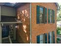 Corner view of a brick townhome featuring a dark front door and matching shutters at 202 Garden Ct, Atlanta, GA 30328