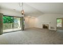 Spacious open-plan living room with vaulted ceiling, fireplace, and sliding glass door to deck at 202 Garden Ct, Atlanta, GA 30328