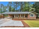 Charming brick home with a covered carport, front porch, and manicured lawn at 2695 Peeler Rd, Dunwoody, GA 30360