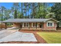 Charming brick home with a covered carport, landscaped front yard, and inviting front porch at 2695 Peeler Rd, Dunwoody, GA 30360