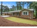 Charming brick home with a covered carport, front porch, and well-maintained yard at 2695 Peeler Rd, Dunwoody, GA 30360