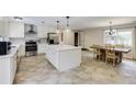 Bright kitchen and dining area with an island, stainless steel appliances, and tile flooring at 5130 N Peachtree Rd, Dunwoody, GA 30338