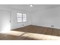 Bright living room with laminate flooring, a window, and a white front door at 5496 Davis Dr, Austell, GA 30106
