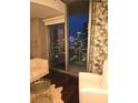 Cozy living room with stylish furnishings and a view of the city skyline at night at 855 Peachtree Ne St # 1912, Atlanta, GA 30308