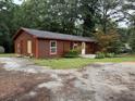 Charming single-story home showcasing painted wood siding and mature landscaping in a tranquil, tree-lined setting at 144 Flat Rock Rd, Oxford, GA 30054