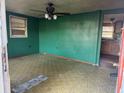 An empty living room showcasing green walls, a ceiling fan, and a window for natural lighting at 144 Flat Rock Rd, Oxford, GA 30054