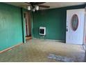 An empty living room showcasing green walls and a heater in the corner, with a view of the front door at 144 Flat Rock Rd, Oxford, GA 30054