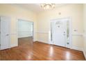 Elegant foyer boasts gleaming hardwood floors, decorative molding, and a stylish front door with glass accents at 5732 Falls View Dr, Buford, GA 30518