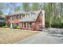 Charming brick home features a well-kept lawn, mature landscaping, and a spacious driveway with a garage at 1010 Allenbrook Ln, Roswell, GA 30075