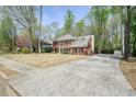 Spacious two-story brick home with a long driveway, mature trees, and a well-maintained lawn at 1010 Allenbrook Ln, Roswell, GA 30075