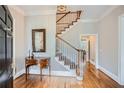 Elegant foyer with hardwood floors, staircase, decorative table, and soft neutral wall colors at 4503 Payton Oaks Ne Pl, Atlanta, GA 30345