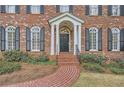 Inviting front entrance with brick walkway, classic black door, and manicured greenery enhancing curb appeal at 4503 Payton Oaks Ne Pl, Atlanta, GA 30345