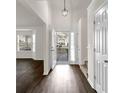 Bright entryway boasts sleek, dark wood floors and a contemporary pendant light fixture at 4720 Buffalo St, Fairburn, GA 30213