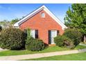 Classic brick home with manicured shrubs and green lawn under a blue sky, creating a welcoming curb appeal at 4820 Camden Sw Dr, Conyers, GA 30094