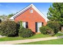 Beautifully landscaped red brick house with green lawn and symmetrical shrubbery at 4820 Camden Sw Dr, Conyers, GA 30094