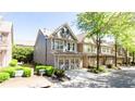 A lovely view of the townhome's facade, green lawn, and an attached two-car garage at 5715 Keys Way, Lithonia, GA 30058
