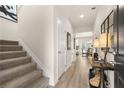 Inviting hallway featuring wood floors, staircase, neutral paint and decor, with an open view to the dining and kitchen area at 112 Maplewood Ln, Conyers, GA 30094