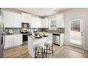 Modern kitchen with white cabinets, stainless steel appliances, central island with bar seating, and direct access to the backyard at 112 Maplewood Ln, Conyers, GA 30094