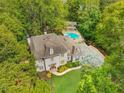 Stately home with manicured lawn, mature trees and a backyard pool and pool house at 302 Rolling Rock Se Rd, Marietta, GA 30067