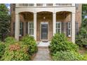 Close-up of home's front door, flanked by lush landscaping and shuttered windows at 3241 Adams St, Atlanta, GA 30337