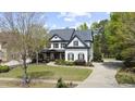Stunning two-story home with a lush green lawn, complemented by mature trees and a curved driveway, exhibiting curb appeal at 6025 Golf View Xing, Locust Grove, GA 30248