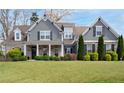 Charming two-story home features a welcoming front porch and beautifully landscaped front yard at 1344 Chipmunk Forest Chase, Powder Springs, GA 30127