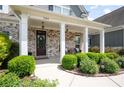 Inviting front porch with stylish columns, brick accents, and manicured landscaping at 1344 Chipmunk Forest Chase, Powder Springs, GA 30127