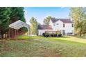 Backyard featuring a deck, a canopy-covered area, and a spacious lawn for outdoor activities at 4014 Ivy Trace Ln, Ellenwood, GA 30294